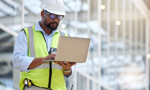 Architecture, research and laptop with black man in warehouse for engineering, building and design. Technology, planning and digital with face of contractor for project management and graphic