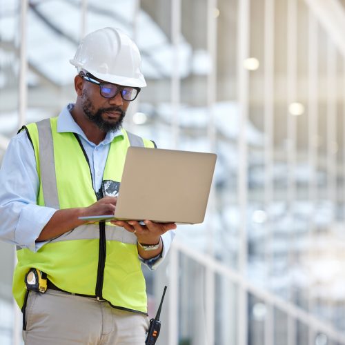 Architecture, research and laptop with black man in warehouse for engineering, building and design. Technology, planning and digital with face of contractor for project management and graphic
