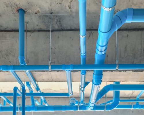 A low angle shot of industrial blue pipes on a ceiling
